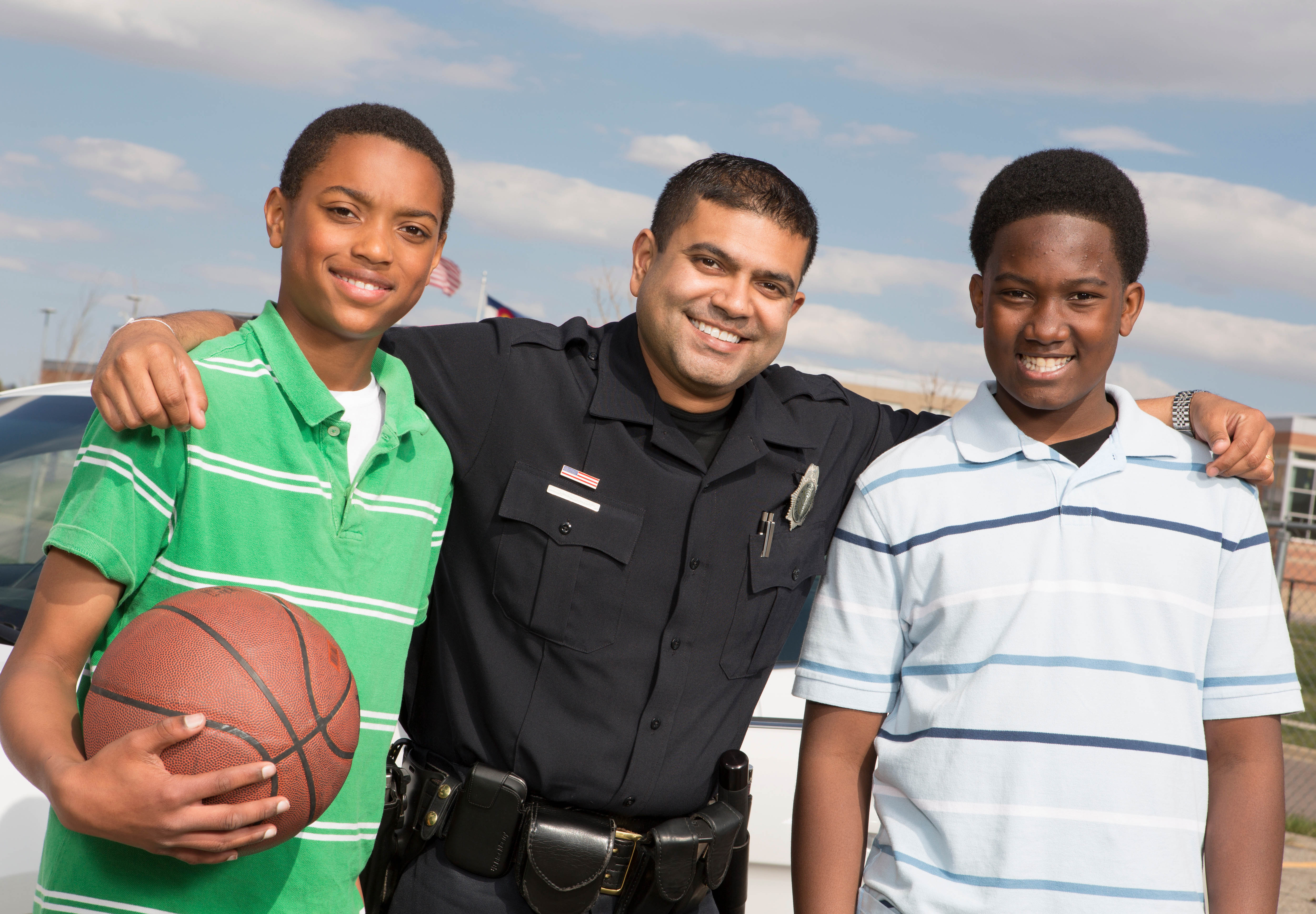 A police officer stands with two teens