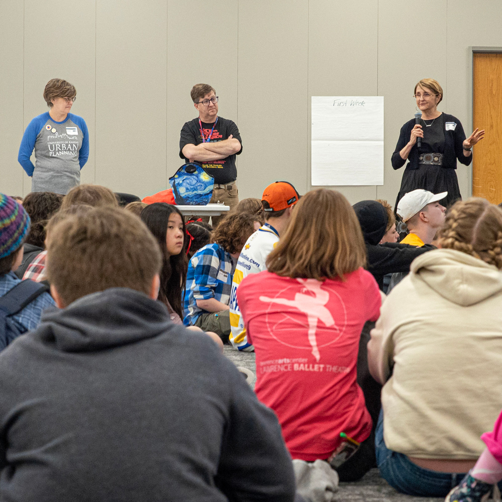 Teachers and Jackie Counts speaking in front of the group of middle school children 