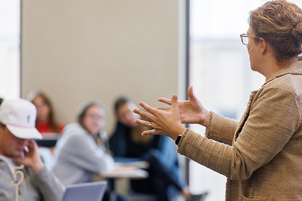 A woman teaches in front of a classroom.