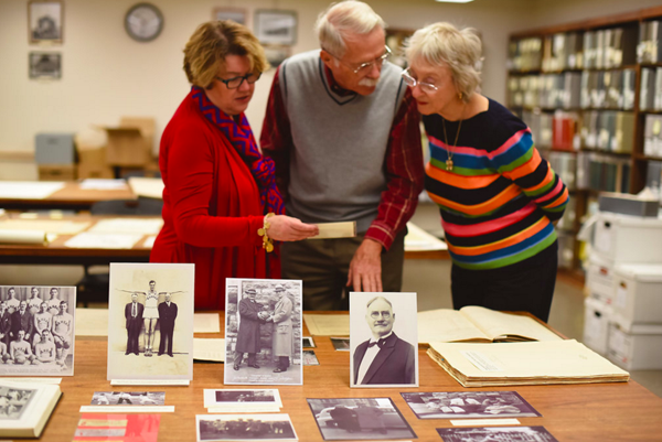 Rebecca Schulte, Jim and Beverly Naismith looking over artifacts