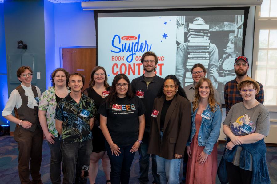 All 11 contestants in the 2026 Snyder Book Collecting Contest are posed in front of the event logo in Watson Library's 3 West Reading Room.