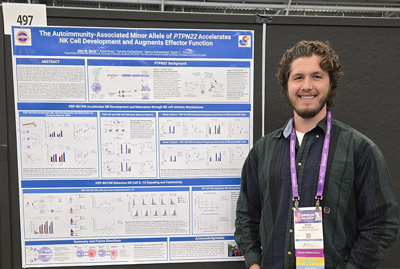 Alec Bevis in front of research posters