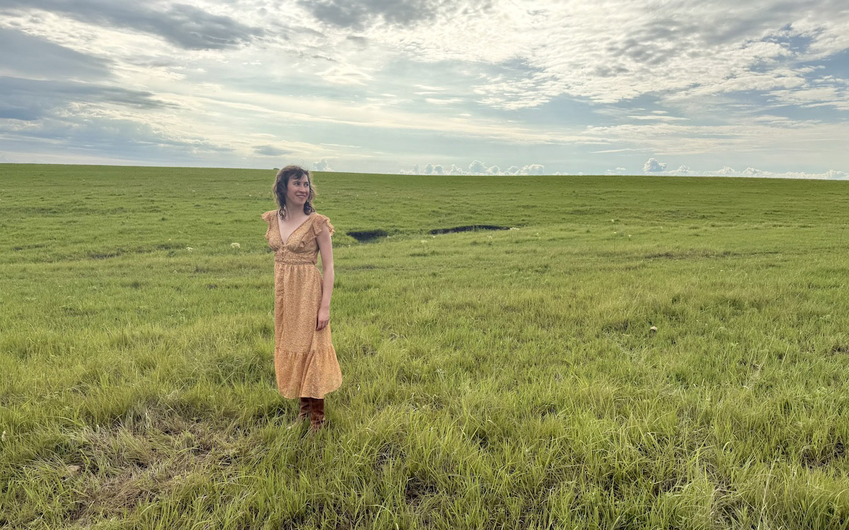 Megan Kaminski stands in prairie setting.