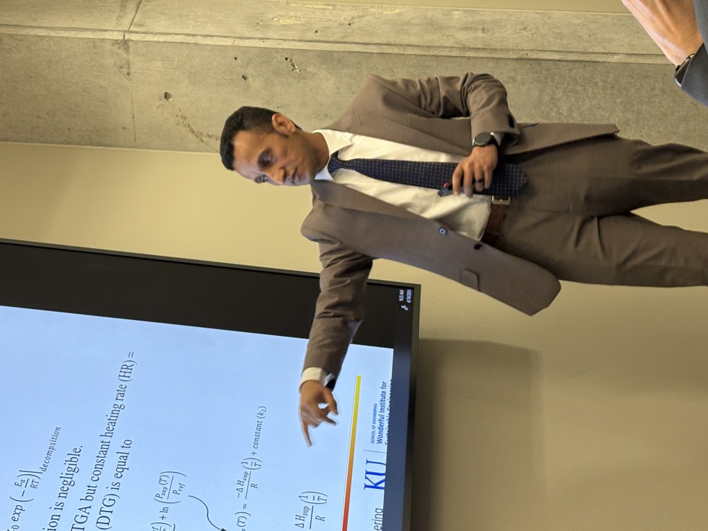 Person stands in front of projector screen while speaking