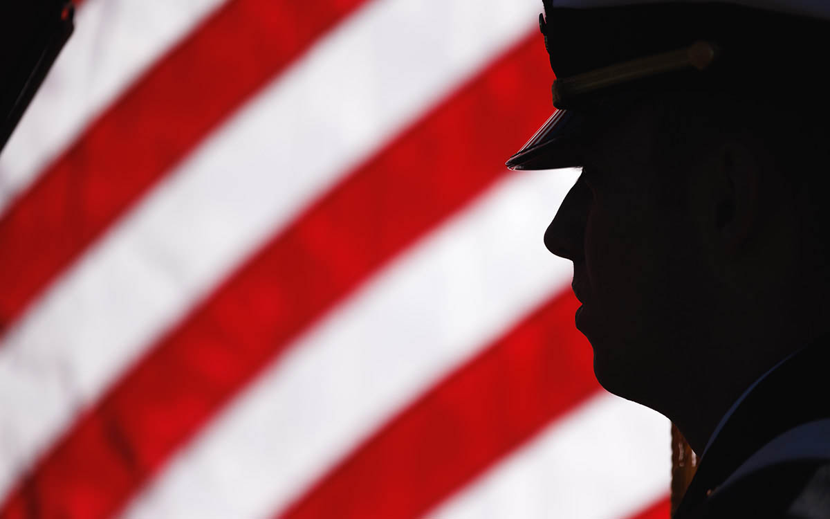 Silhouette of KU ROTC cadet in front of American flag.