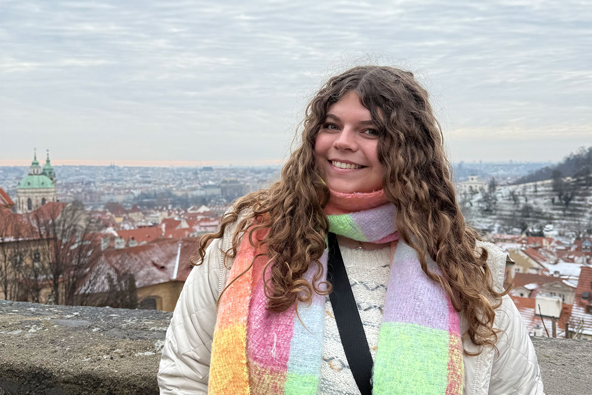 Student stands in front of Prague skyline