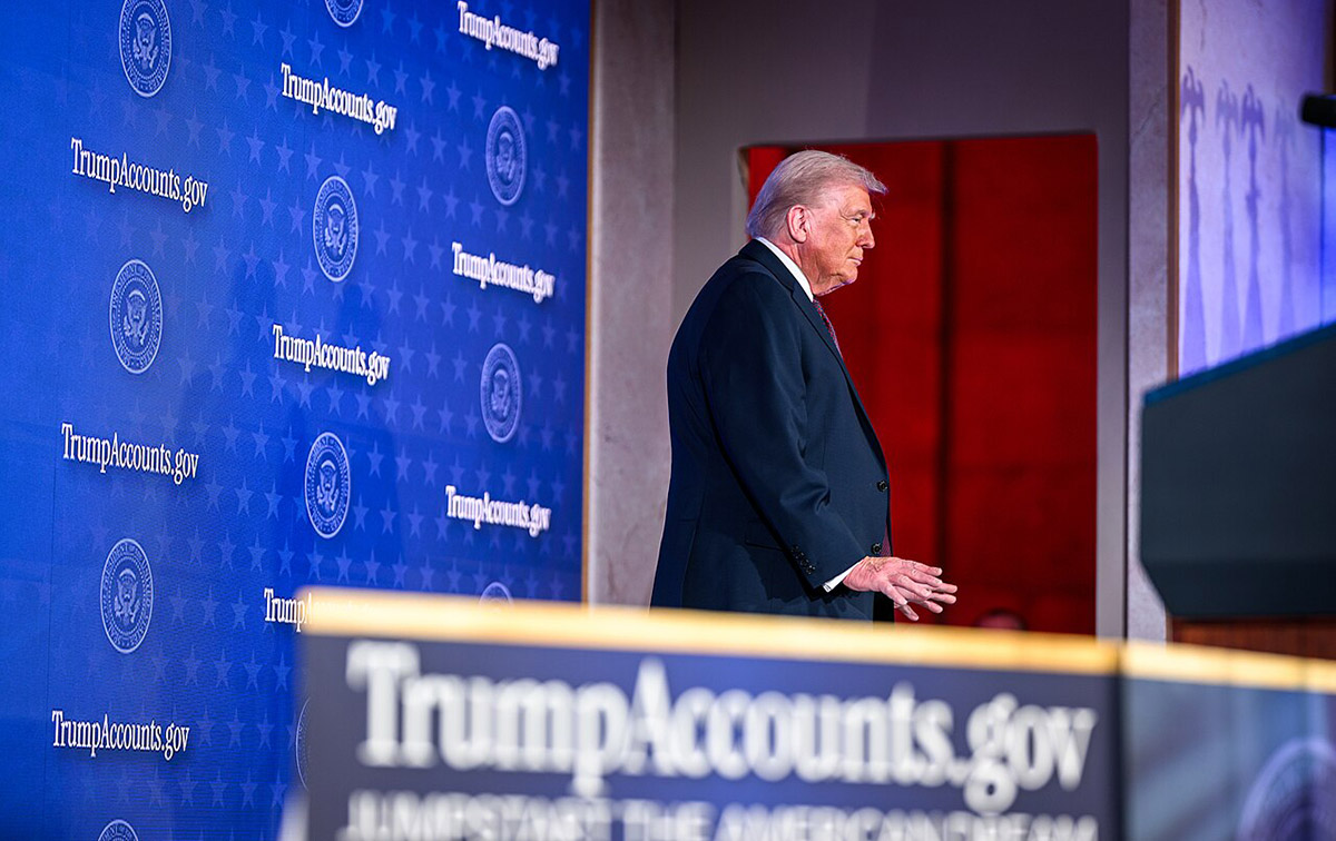 Donald Trump speaking with TrumpAccounts.gov signage in background