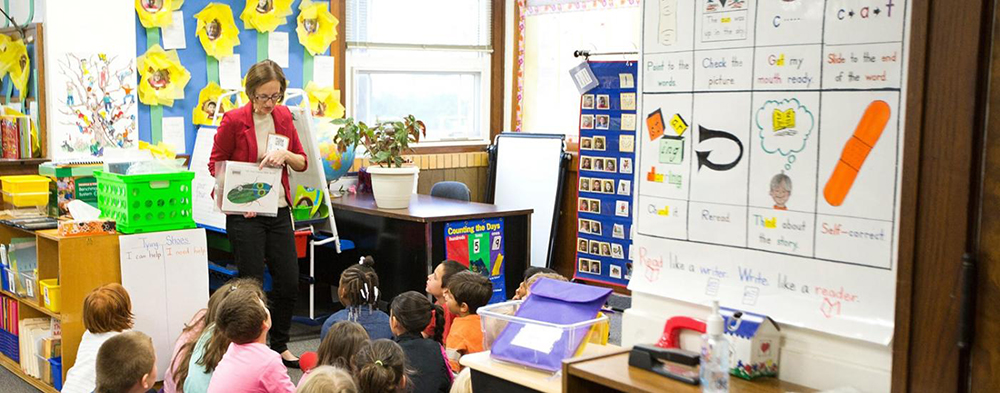 Teacher in early childhood education classroom. Stock image.