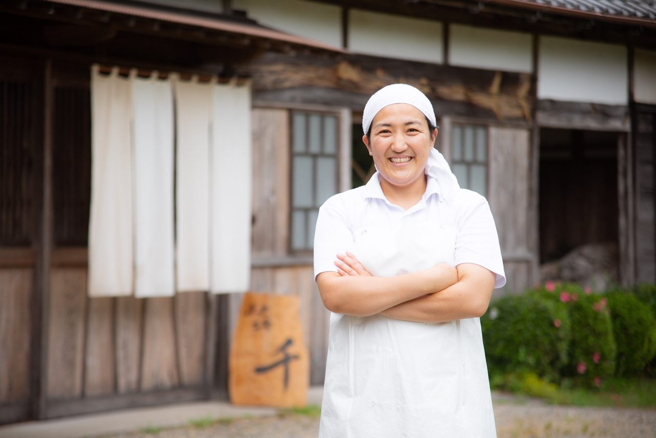 cheese monger stands in front of shop