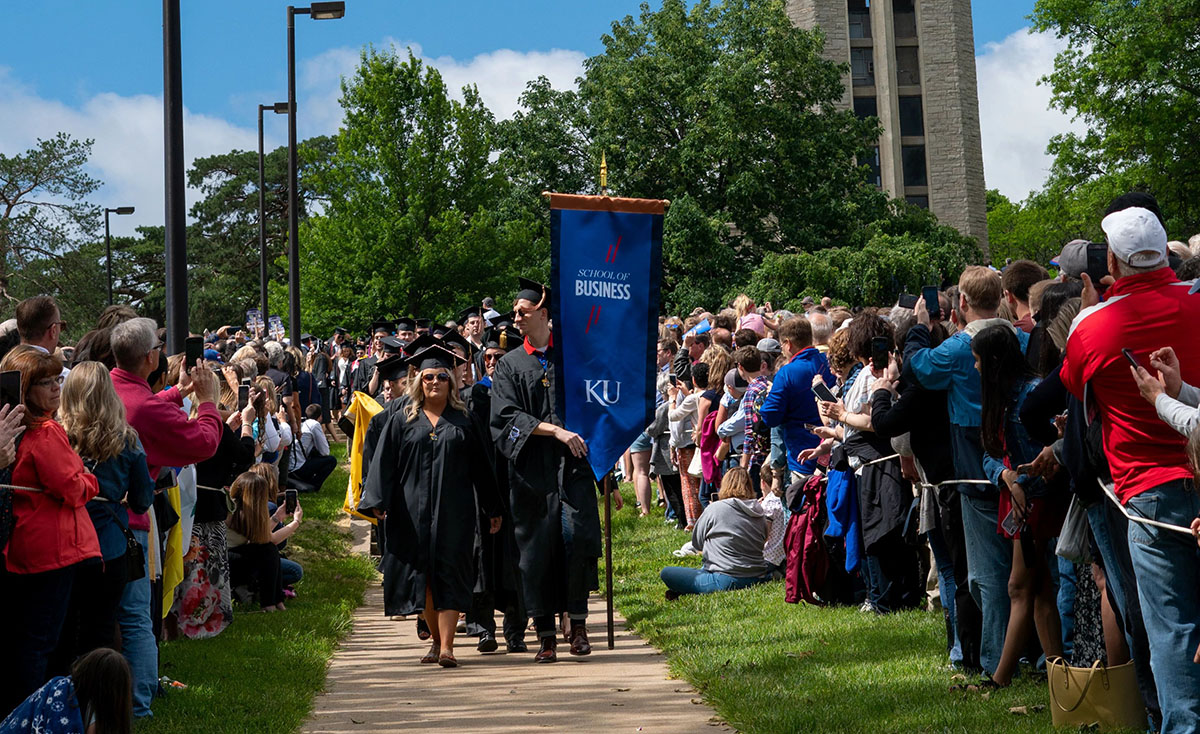 School of Business graduates walk down the Hill past the Campanile on a sunny day for Commencement, 2019.