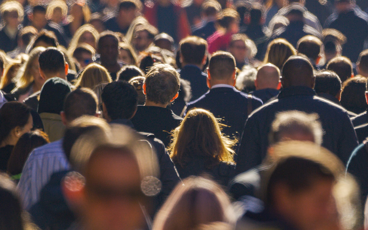 Crowd walking through urban space.