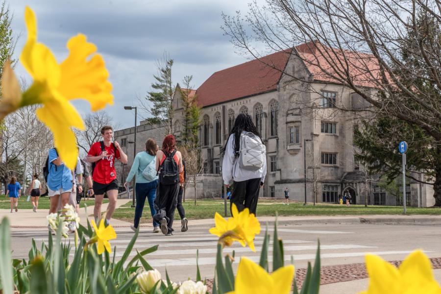 Students use the crosswalk with Watson Library in the background.
