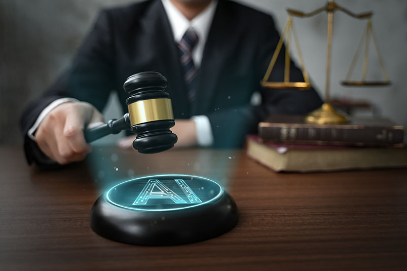 Individual in suit striking gavel on button that reads "AI." Justice scales elsewhere on desk. Image credit: Adobe stock.
