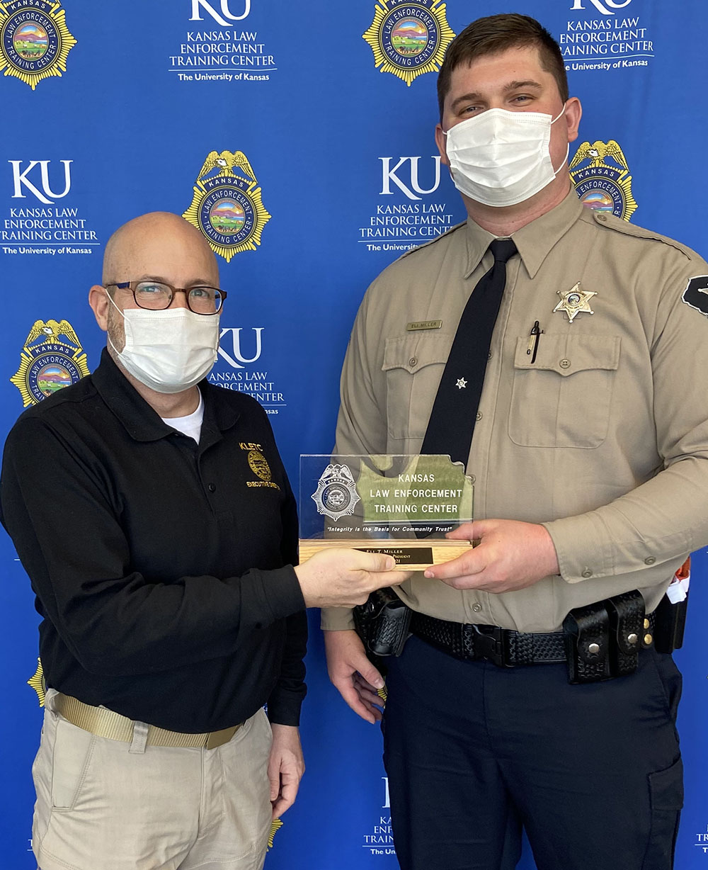 KLETC Executive Director Darin Beck presents Deputy Eli Miller of the Pottawatomie County Sheriff’s Office, the graduation class president, with his plaque.