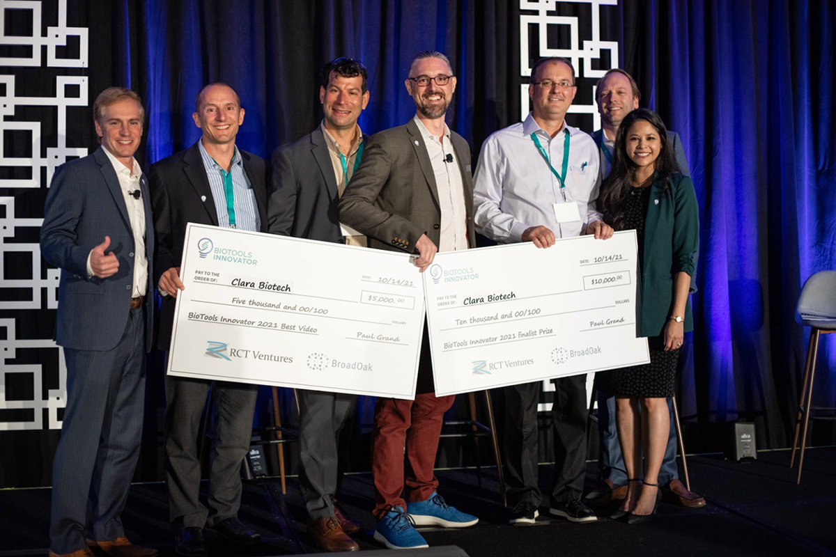 Jim West, CEO of Clara Biotech, holds the two checks his company won at MedTech Innovator’s Biotools Innovator program in San Diego in October.