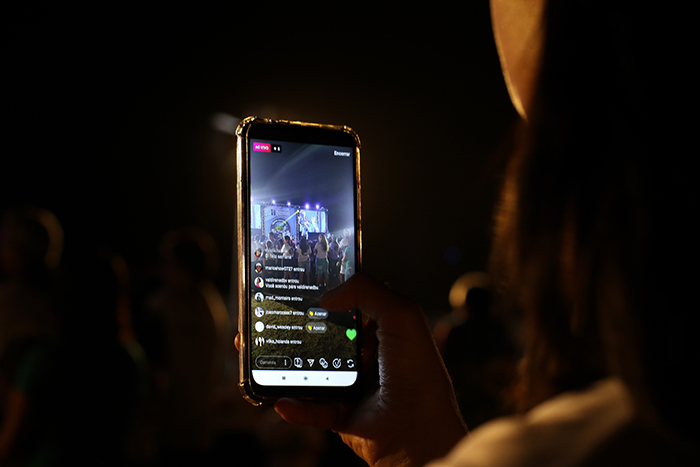 Person holding cellphone to stream an event