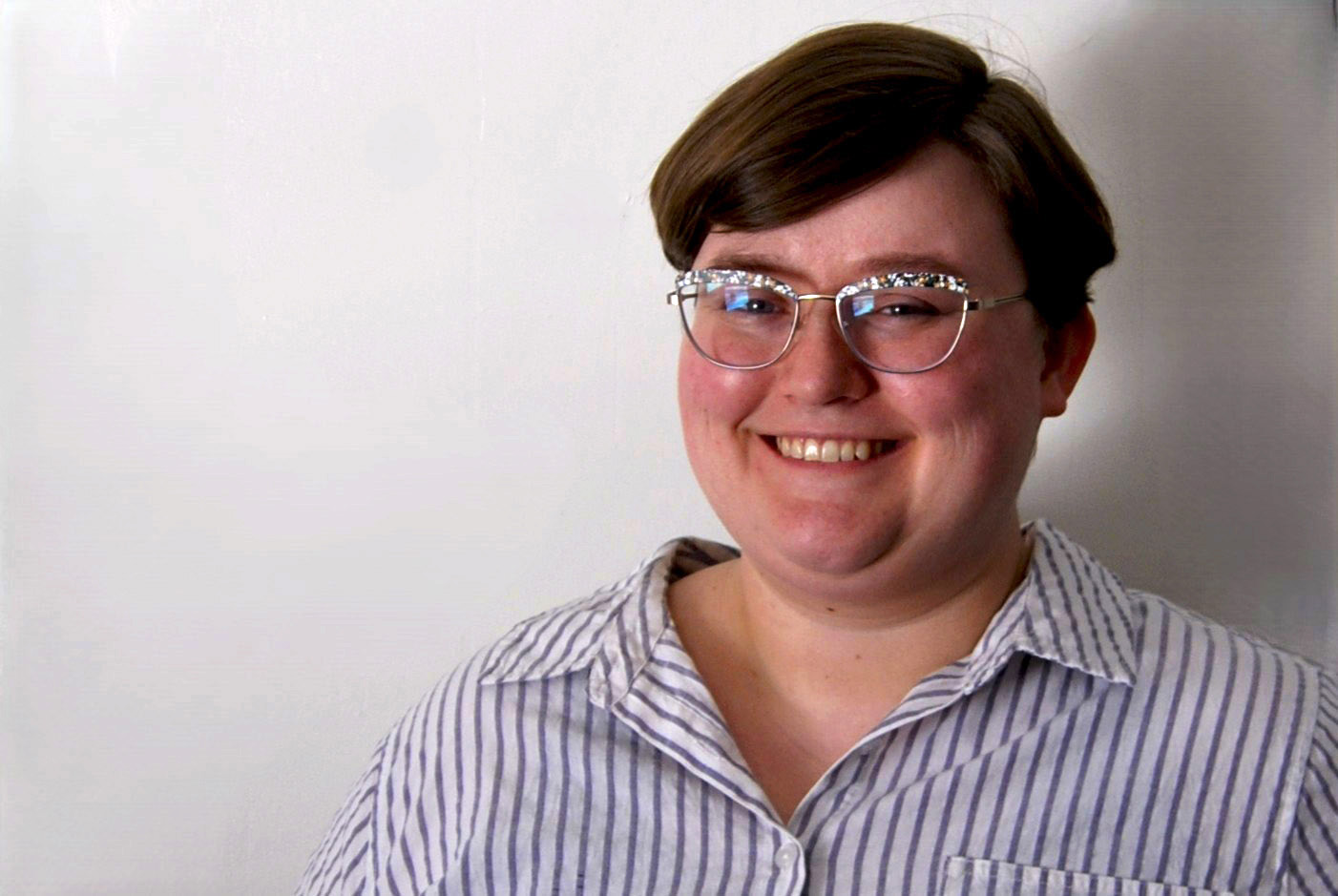 Victoria Quirk smiling and wearing a purple-striped shirt