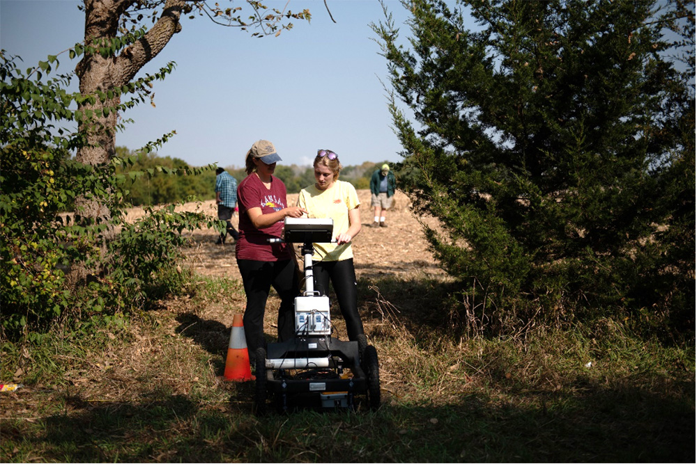 Blair Schneider shows Madison Rice, undergraduate research assistant, how to use ground-penetrating radar.