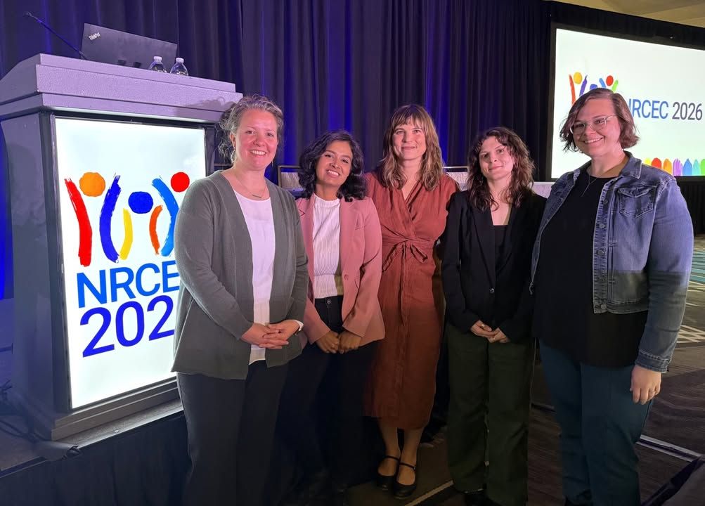 the team in front of the NRCEC conference presentation