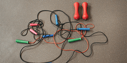 Brightly colored tangle of jump ropes, weights.