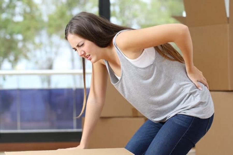 Woman hurts back while lifting moving boxes