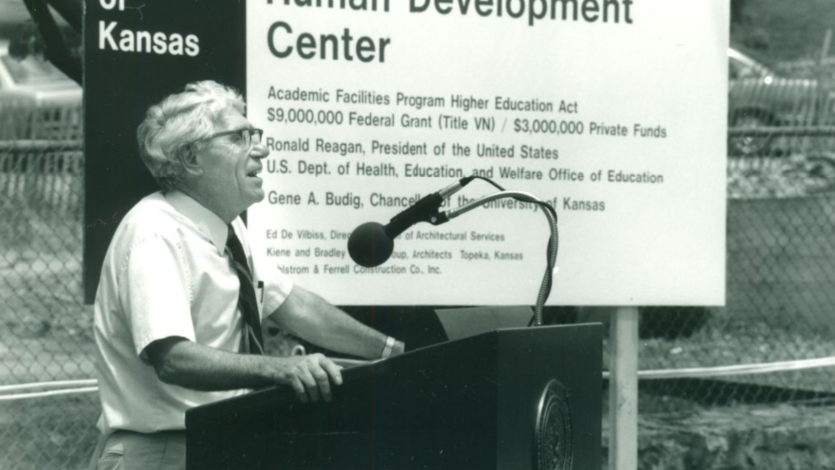 ""Richard L. Schiefelbusch speaks at a podium outside the Robert Dole Human Development Center""