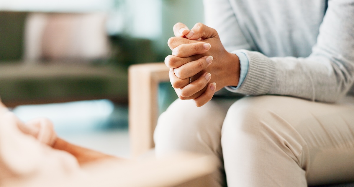 Stock photo of woman's hands with psychologist in consultation office for assessment or evaluation.