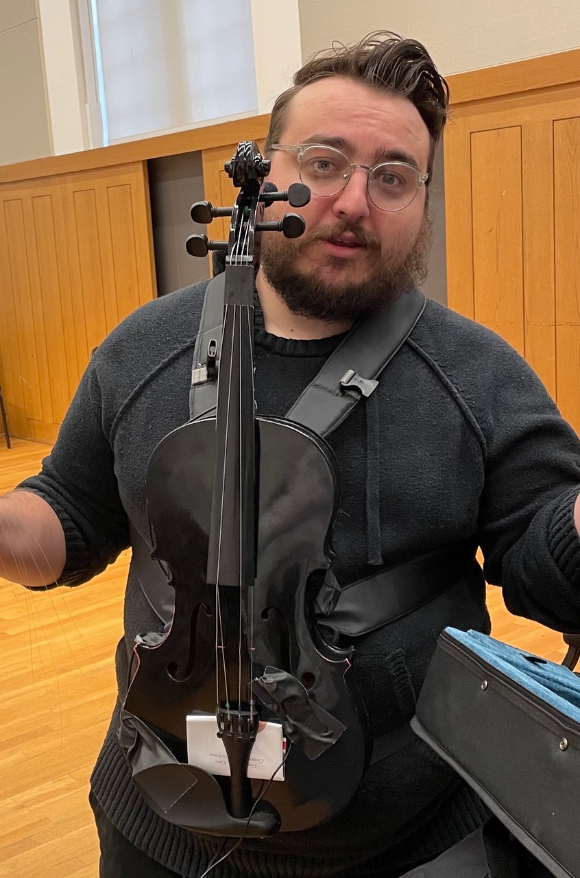 a man wearing black and holding a black instrument