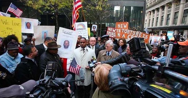 Photo: Jonathan Jackson (center left) stands with Atty. G. Flynt Taylor (center right) during a press conference on wrongful convictions outside a federal courthouse in Chicago in 2012. Wikimedia Commons photo.