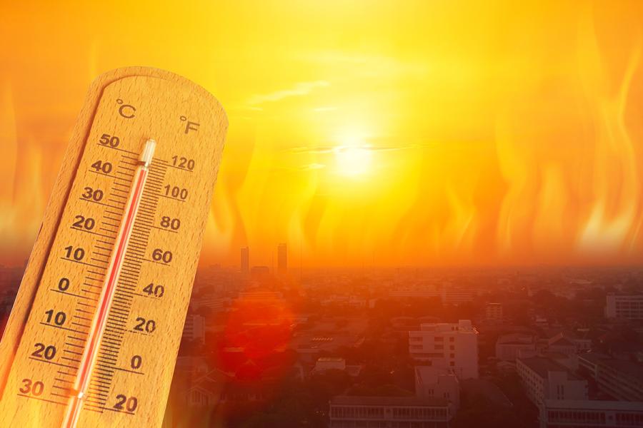 A photo illustration of a thermometer hitting high temperatures against the backdrop of a city.