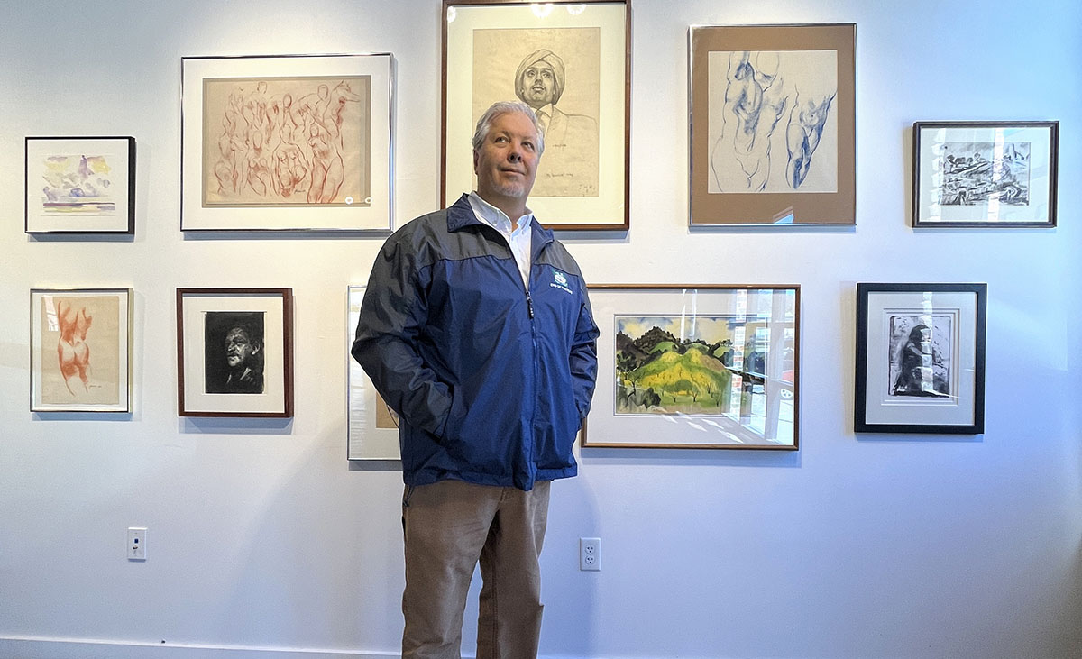 Stephen T. Johnson standing in front of gallery wall.