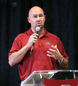 Judd Norris speaking at podium.