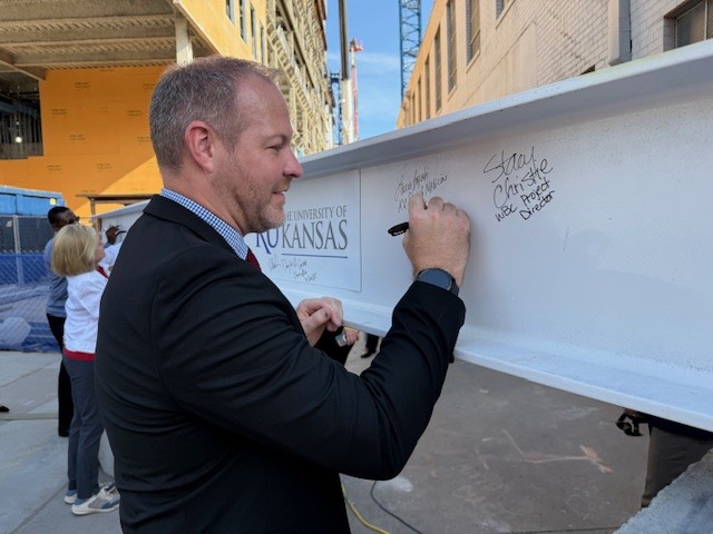 Brad Newell, associate dean for Wichita, signs a final beam to be installed in the Wichita Biomedical Campus.