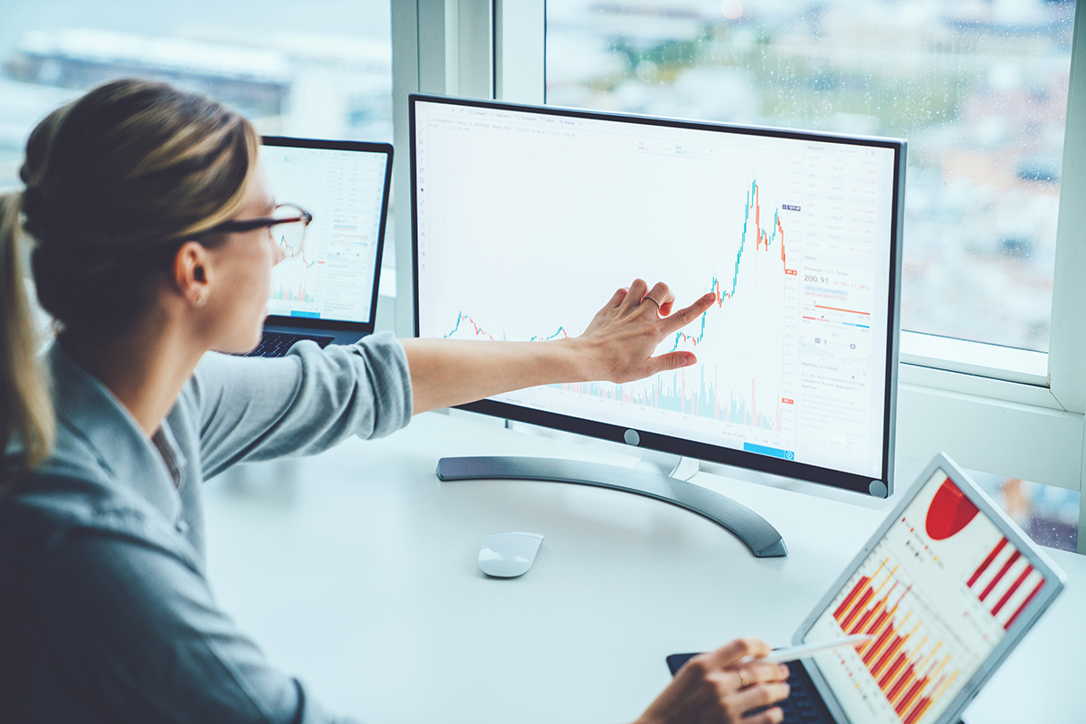 woman looking an line graph on computer screen