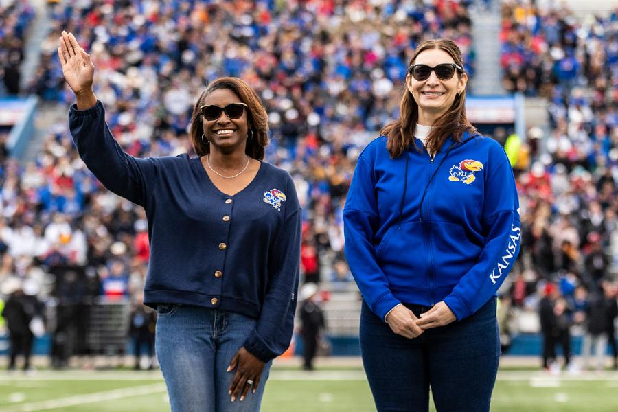 KU professor Jomella Watson-Thompson is recognized for research excellence at a KU football game. She is standing next to Alicia Doan, associate dean for research in the College of Liberal Arts & Sciences, on the football field.