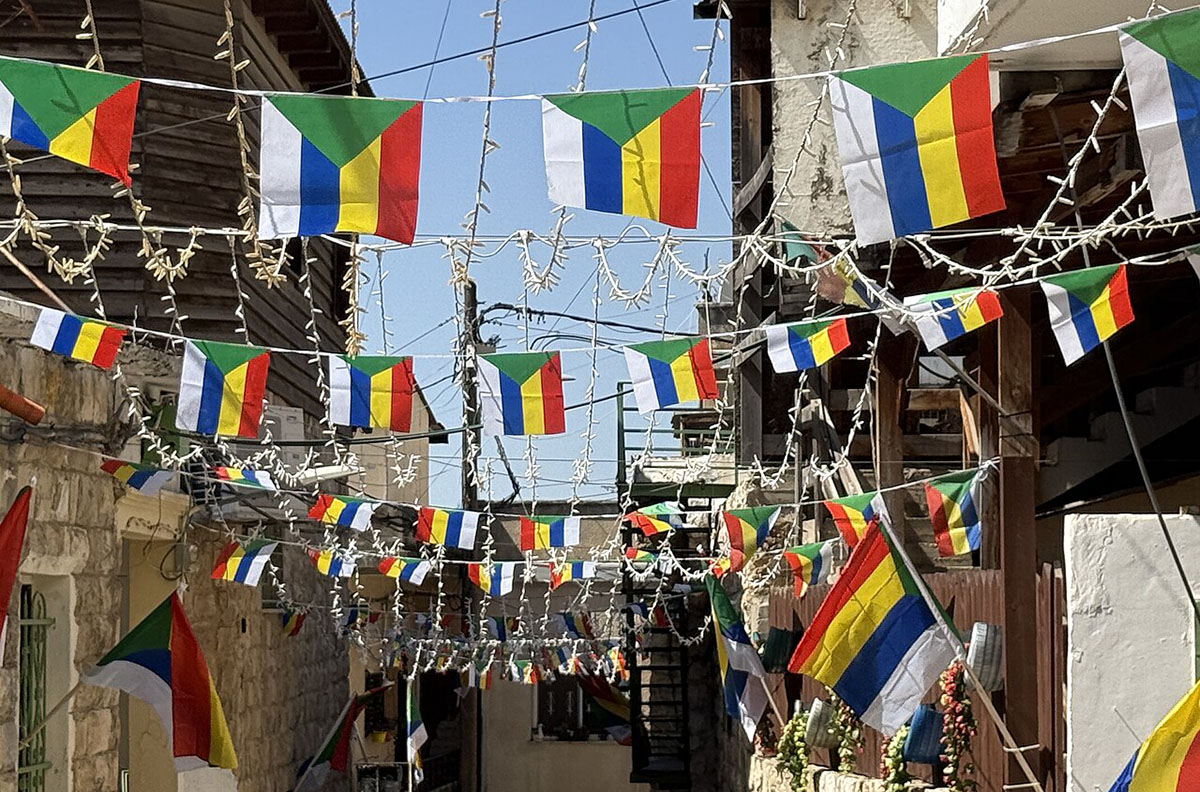 Street festooned with multi-colored, striped flags.