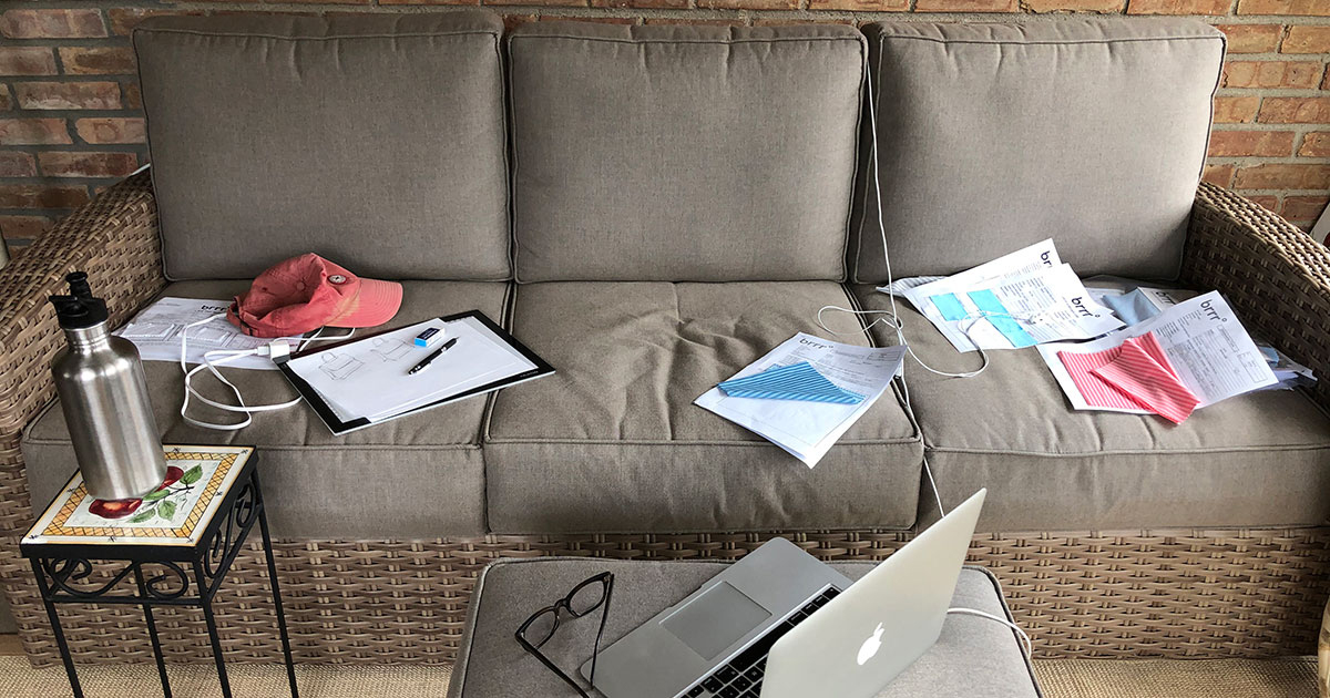 Couch with scattered papers and laptop