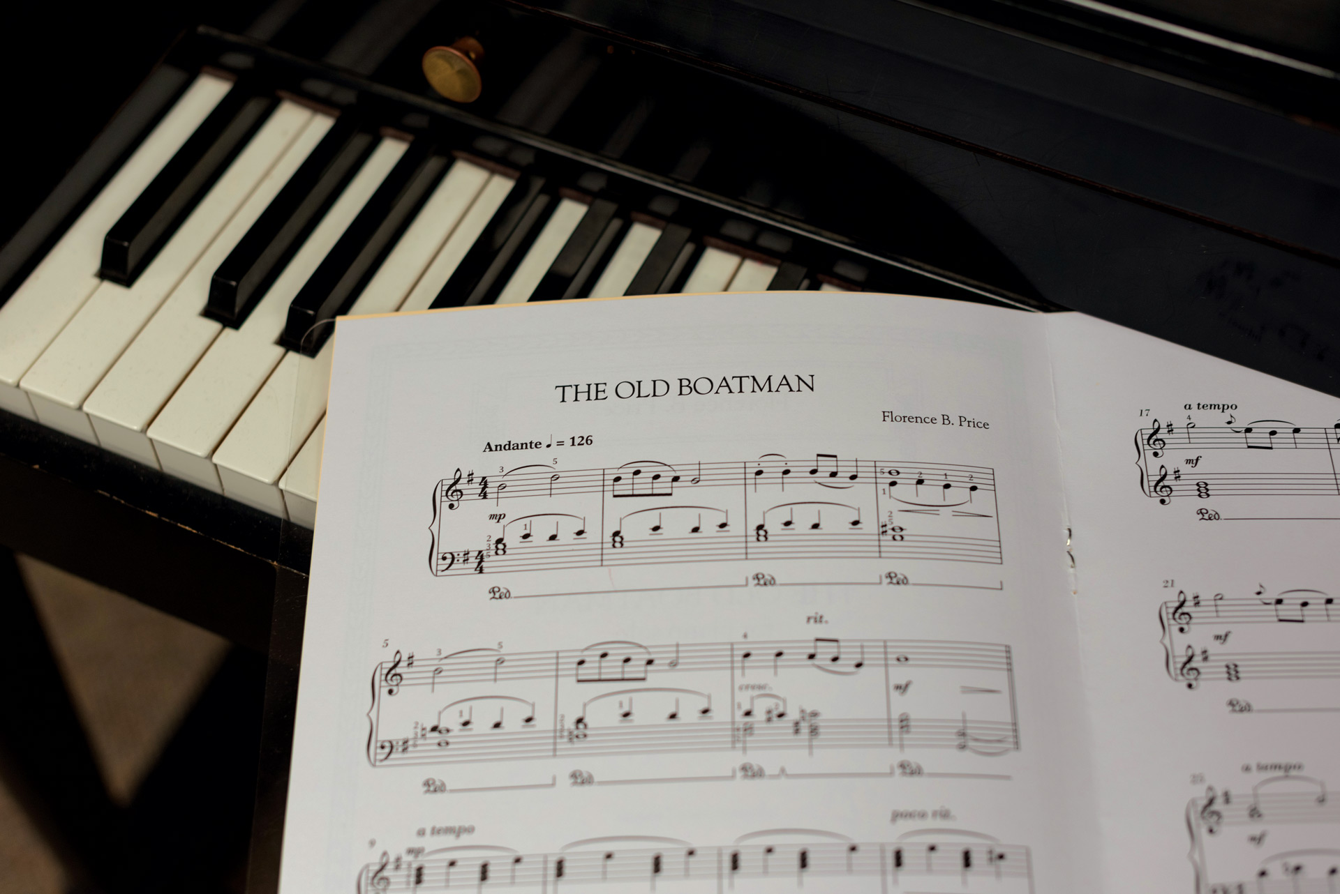 Sheet music of "The Old Boatman" by Florence Price in front of a piano keyboard. 