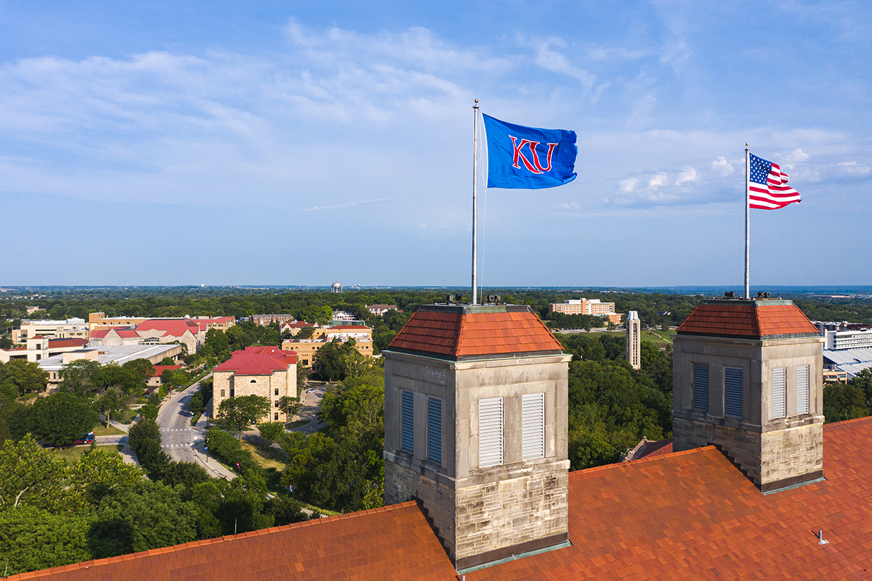 KU and American flags displayed on the roof of KU's Fraser Hall