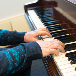 Andrew Morgan's hands playing piano in Watson Library. 