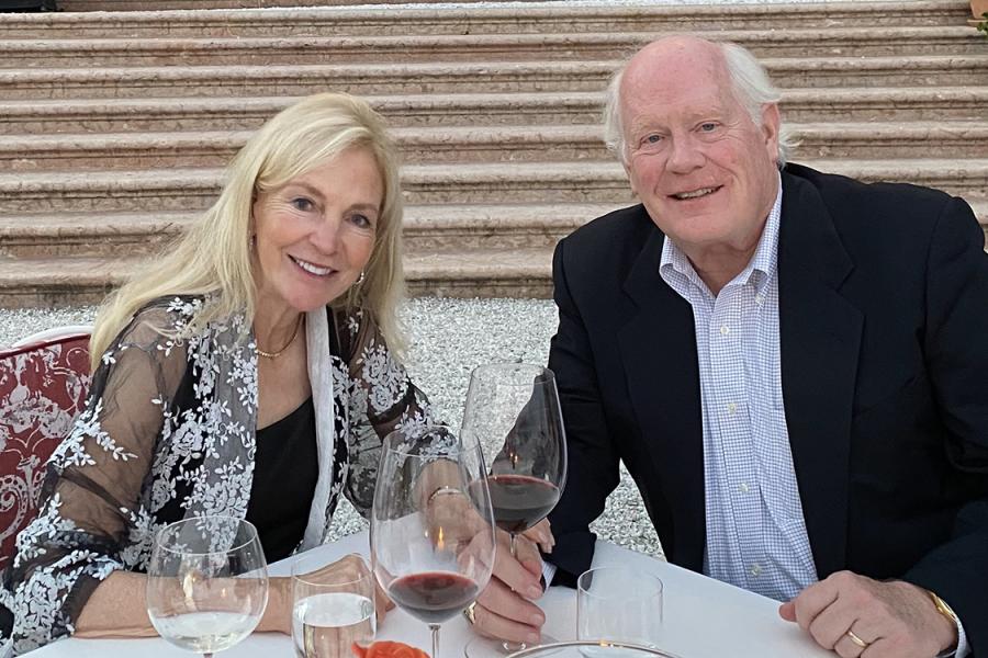 Linda DeBruce and Paul DeBruce seated at an elegantly set outdoor cafe table.