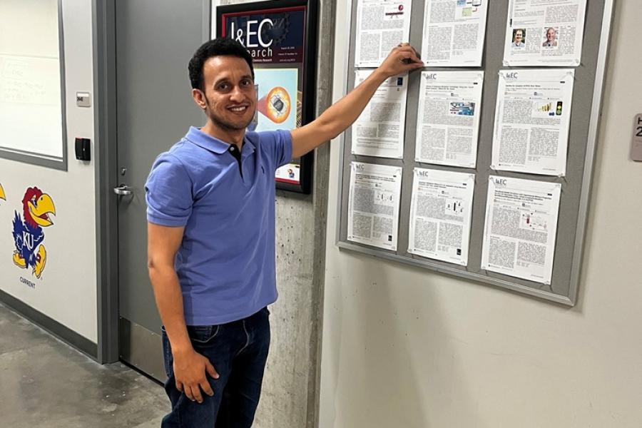 Arishi Abdulrhman pins his research to the publication wall at KU