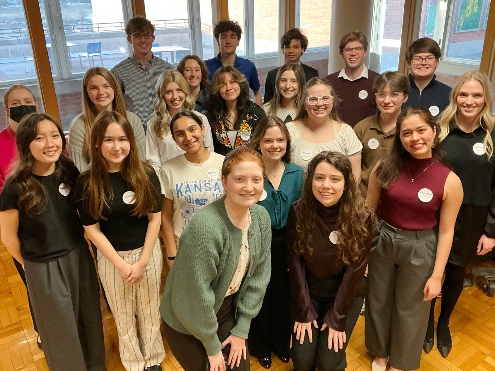 Students pose for group photo by piano.