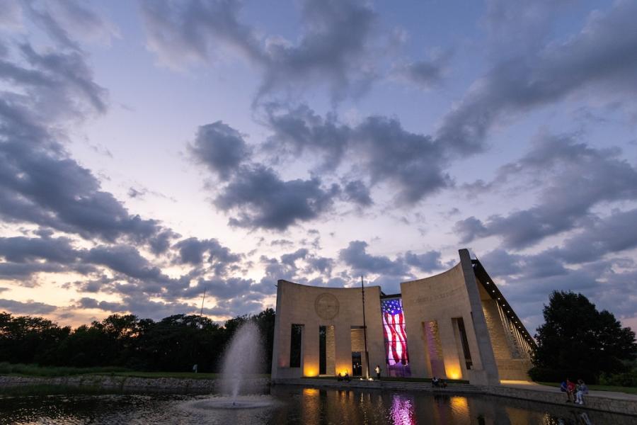 Dole Institute of Politics with clouds at sunset in the background, pond in the foreground