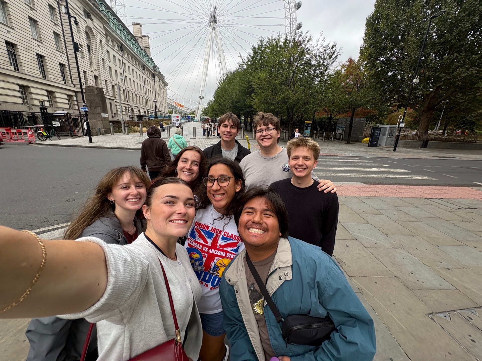 Students pose in front of the London Eye.