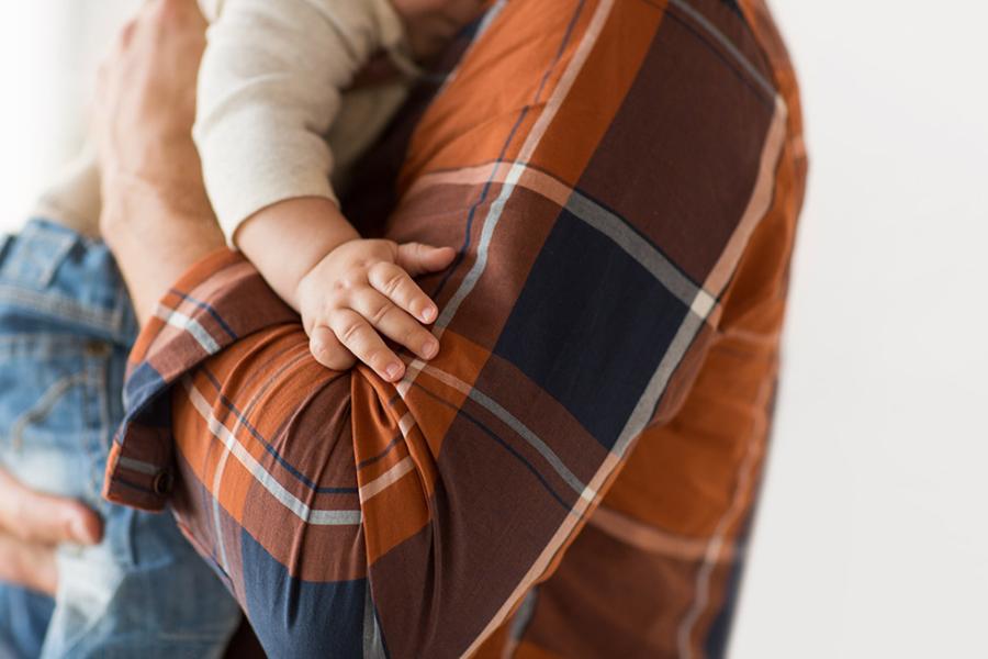 A closeup image of a man holding his young child.