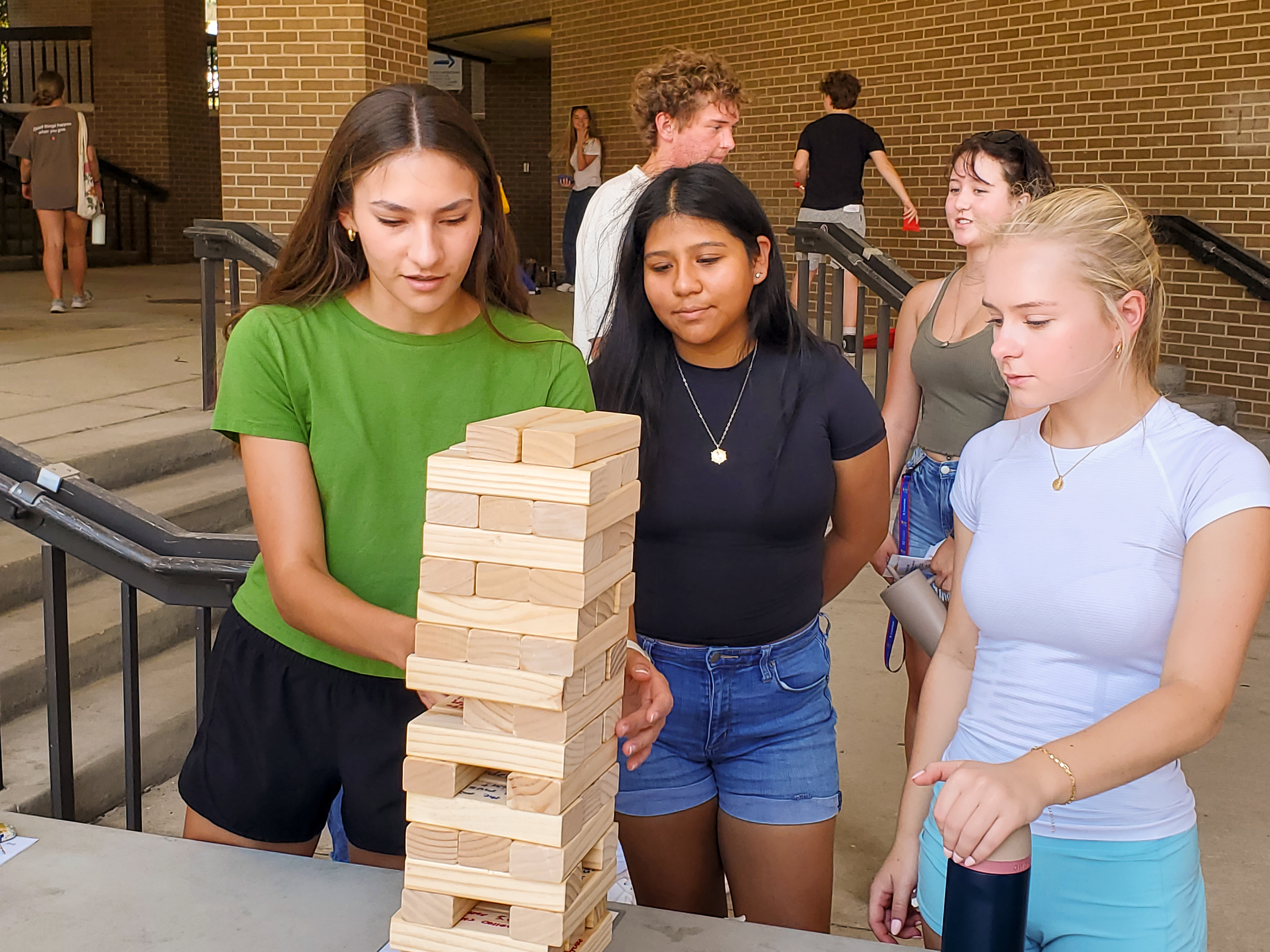 Three students play Jenga