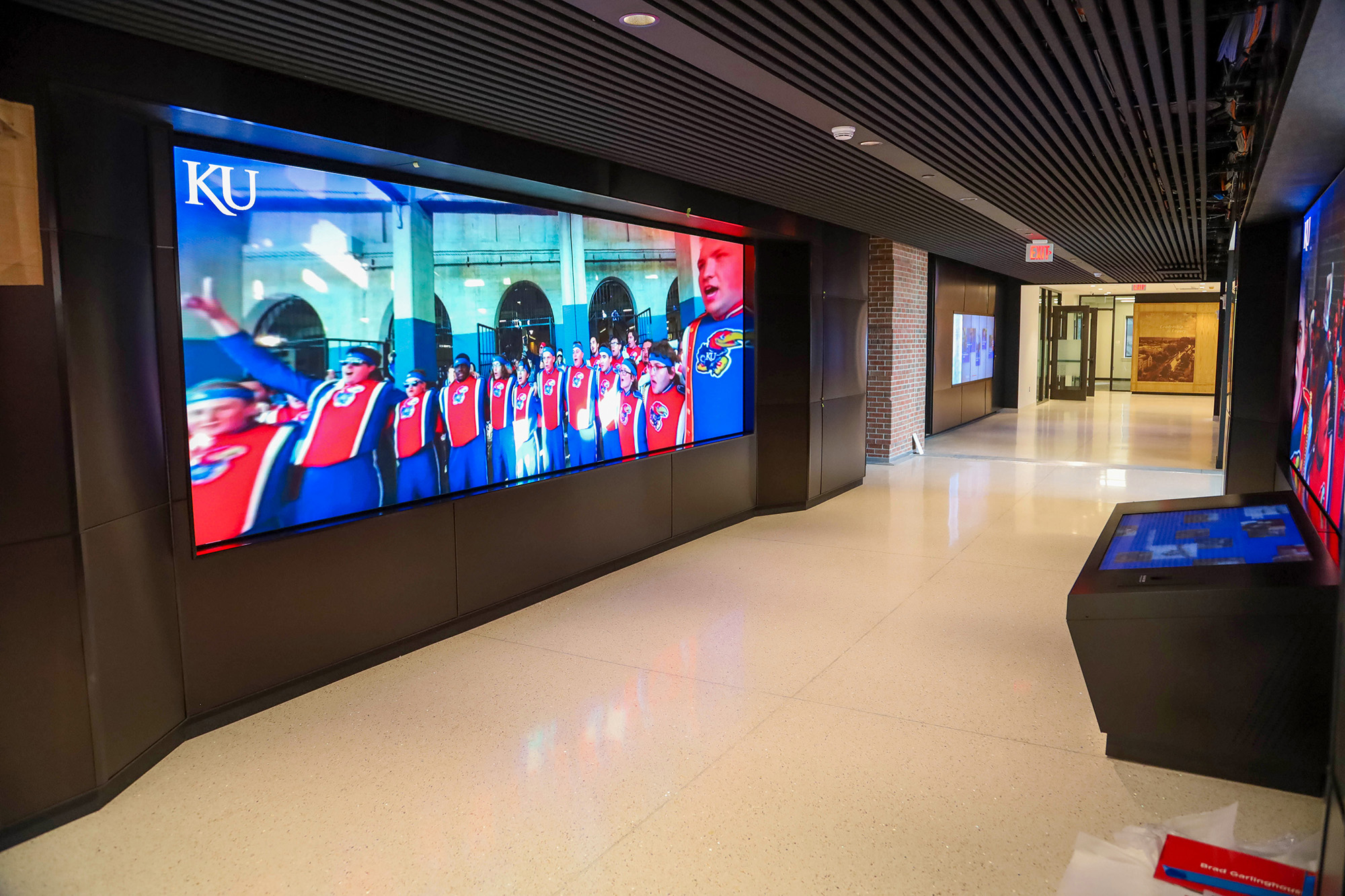Jayhawk Welcome Center interior with widescreen project showing Marching Jayhawks.