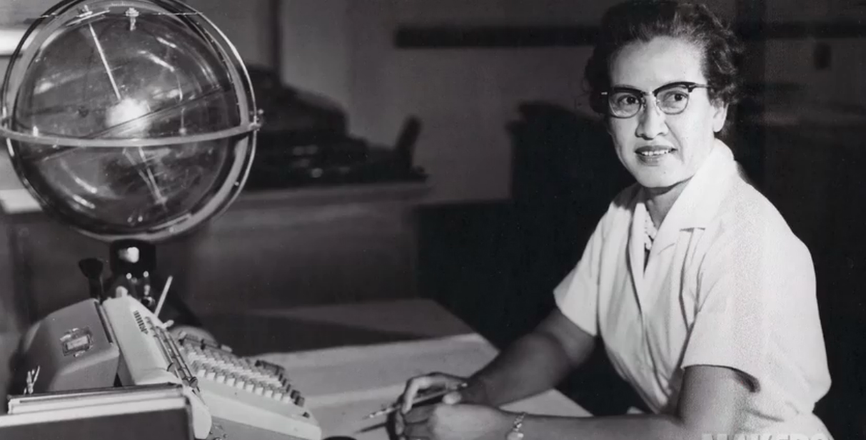 An archival photo of Katherine Johnson working at her desk at NASA.