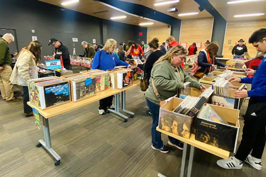 Two dozen people look through boxes filled with records at the Lawrence Library.